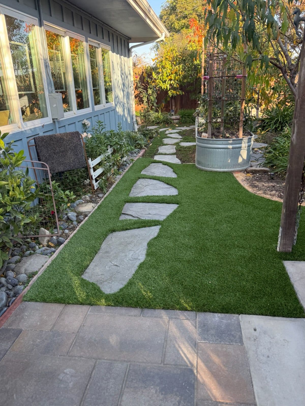 Stunning Side Garden with Stone Path and Artificial Turf image